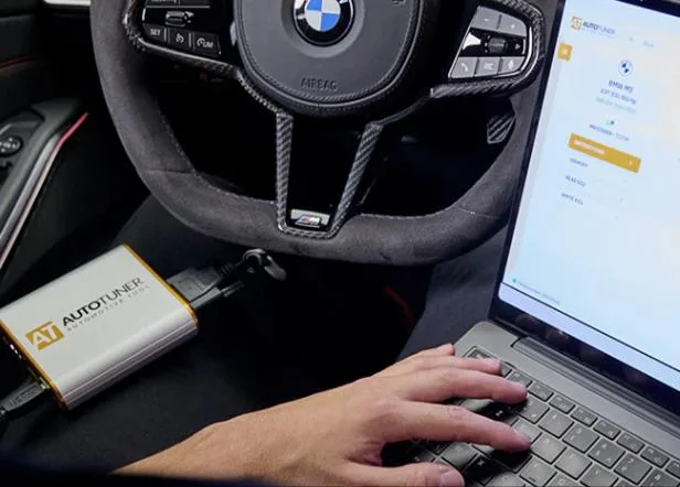 AutoTuner programming equipment connected to a vehicle beside a workshop laptop